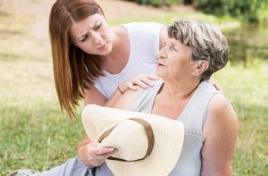 Concerned woman caring for a senior mom outdoors