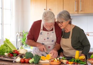 Man and woman enjoying fresh vegetables at home