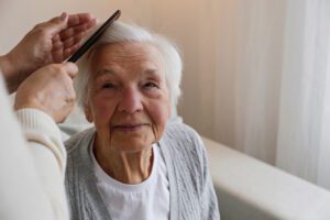 older woman smiling while her hair is being brushed