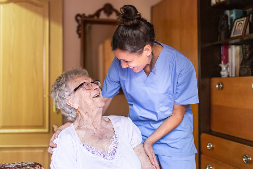 older woman and nurse smiling at each other