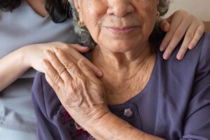 elderly woman holding hand of hospice nurse