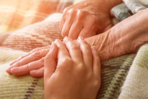 hospice nurse holding patients hand