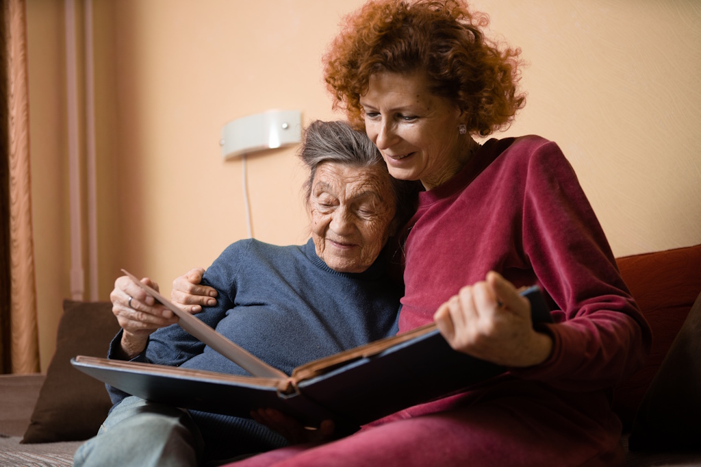 senior woman with daughter looking at photos