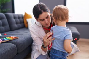 home health nurse checking toddlers heart