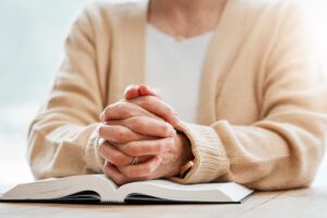 senior woman with folded hands praying