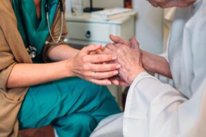 hospice nurse holding womans hands