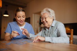 senior woman and caregiver doing puzzle