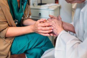 hospice nurse holding patients hand