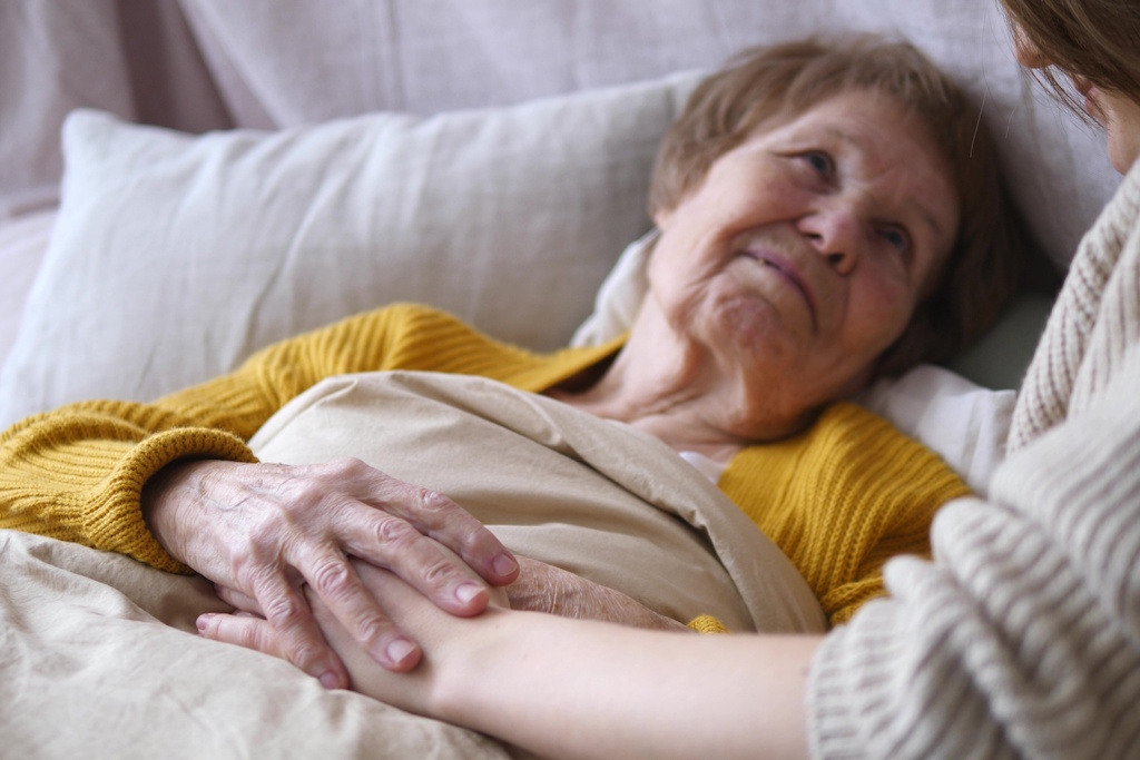 woman on hospice holding family member's hand