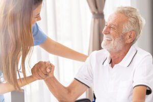 senior man smiling at home health nurse