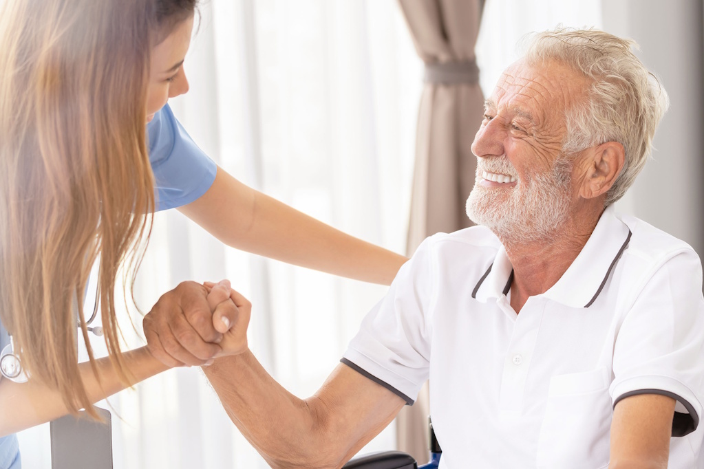 senior man smiling at home health nurse