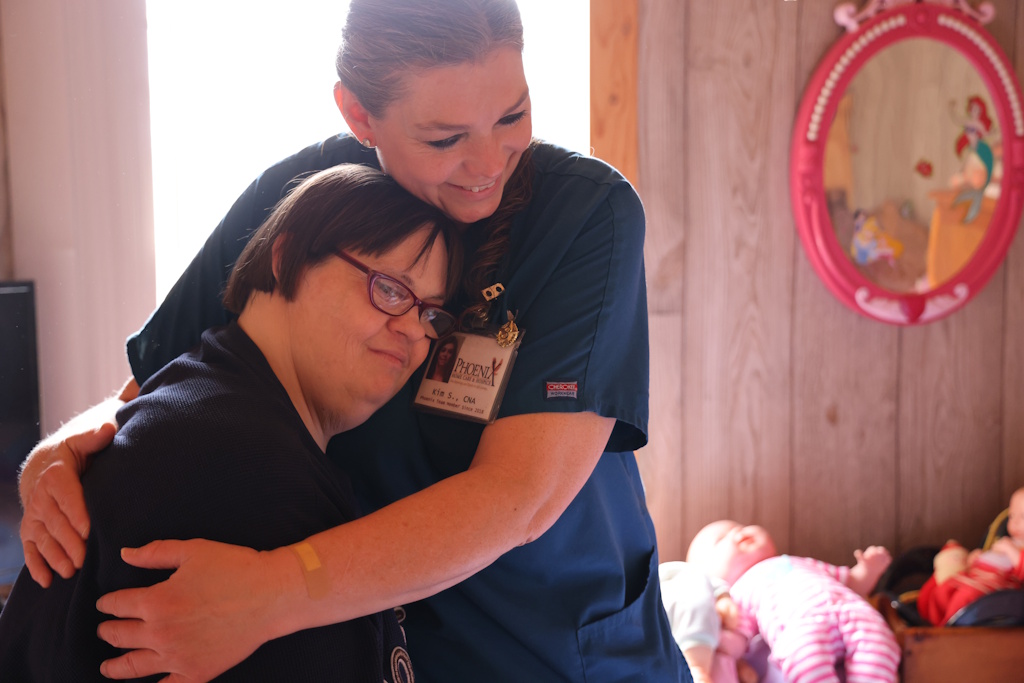 home health nurse hugging patient