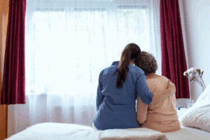woman hugging senior mother on bed