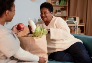caregiver helping senior woman with groceries