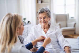senior woman getting help with buttoning shirt