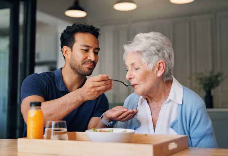 in home caregiver helping with breakfast