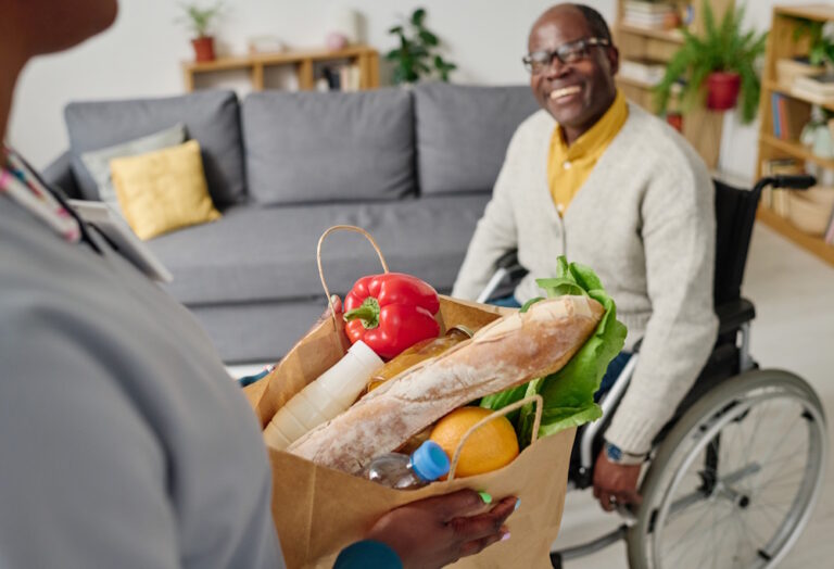 caregiver bringing groceries to patient