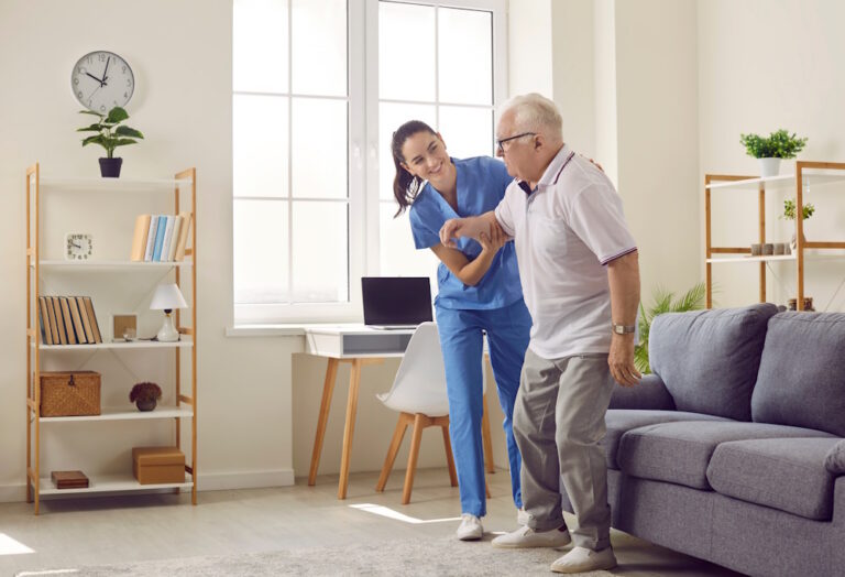 caregiver helping man walk