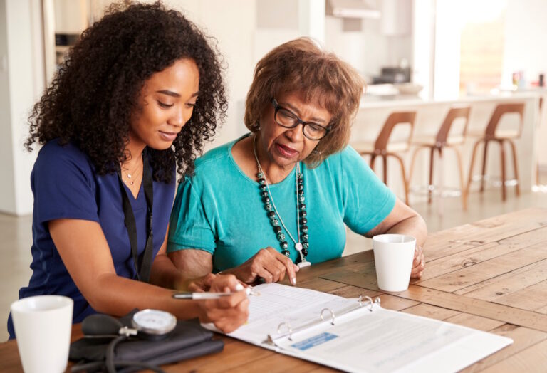senior woman reviewing paperwork with a home health nurse