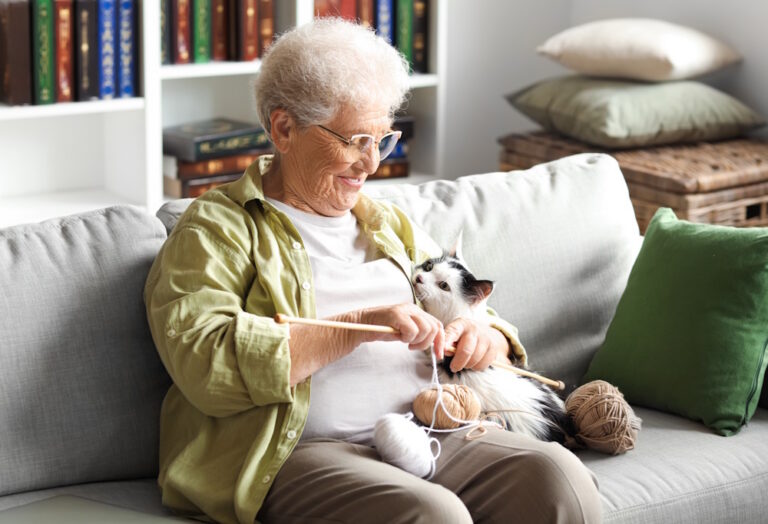 senior woman knitting with cat