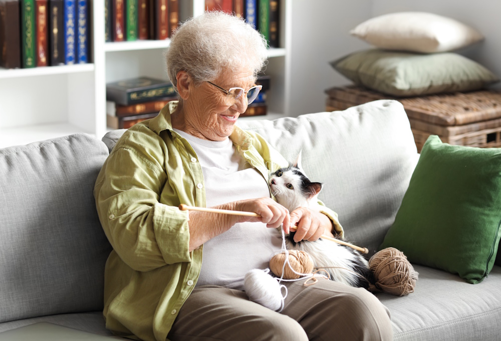 senior woman knitting with cat